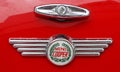Photo of a retro Mini Cooper car logo badge on a red Mini Cooper car. Royalty Free Stock Photo