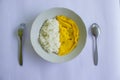 a photo rice with fried egg omelet, with spoon and fork on white plate. isolated on wood background. breakfast with omelet in. Royalty Free Stock Photo