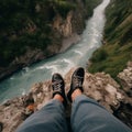Photo of river in gorge taken down from high cliff, photo shows photographer\'s legs,