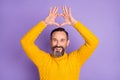 Photo of romantic bearded man raise hands show heart figure wear yellow pullover isolated violet background Royalty Free Stock Photo