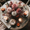 Photo of a round wooden table in Scandinavian style, seen from above. On it, there's a bouquet of dahlias, a candle