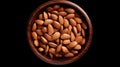Photo of a rustic wooden bowl filled with fresh almonds on a sleek black background