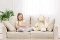 Photo of sad blond girl looking at teddy bear. Royalty Free Stock Photo