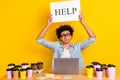 Photo of sad guy arms hold help poster workstation desktop netbook coffee cup isolated on yellow color background