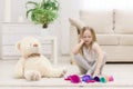 Photo of sad little girl sitting on the floor with toys. Royalty Free Stock Photo