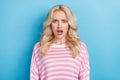 Photo of sad millennial blond hairdo lady wear striped shirt isolated on blue color background Royalty Free Stock Photo