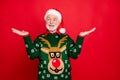 Photo of santa senior man holding sale products on open palms advising low holiday prices wear x-mas ugly ornament