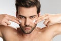 Photo of sassy half-naked man applying facial cream