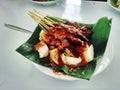 Photo of Sate Beef Suruh, typical of Salatiga Indonesia. Served with Lontong, on a plate covered with leaves.