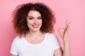 Photo of satisfied woman with perming coiffure dressed white t-shirt showing okey approve good work isolated on pink