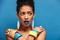 Photo of scared or agitated mulatto woman with colorful makeup a