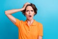 Photo of scared impressed lady wear orange t-shirt open mouth arm head isolated blue color background