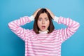 Photo of scared impressed woman wear striped sweater arms head open mouth isolated blue color background