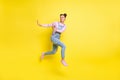 Photo of scared lady jump run away show stop sign wear jeans overall sneakers isolated yellow background