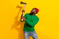 Photo of scared lumberjack man hold sharp axe scared face wear red beanie green pullover isolated yellow color Royalty Free Stock Photo