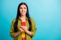 Photo of scared nervous girl hold telephone bite lip look empty space wear green shirt isolated blue color background