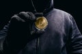 Photo of scary hooded man holding golden euro coin