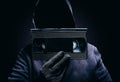 Photo of scary hooded man holding video cassette