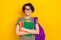 Photo of scary unsure girl dressed green t-shirt eyewear rucksack holding book scary exam isolated yellow color