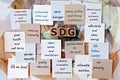 Photo on SDG Sustainable Development Goals theme. Wooden cubes with the acronym `SDG`, and sticky notes