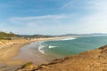 In the photo, the sea bay. The water is azure, white near the shore. Yellow sandy shores. Blue transparent sky. White clouds.