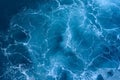 Photo of a sea with foam. Blue surface as background.