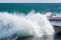 Photo of the sea wave breaking on the concrete mooring on a huge number of splashes