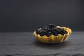 A photo of seafood. Black sturgeon caviar in a tartlet on the dark stone background with copyspace, place for text. Delicatessen