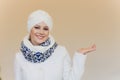 Photo of self assured Arabian lady in hijab, shows you right way, points at blank space with both fore fingers, invites Royalty Free Stock Photo
