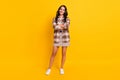 Photo of self-assured lady crossed hands toothy smile wear plaid coat mini skirt shoes isolated yellow color background Royalty Free Stock Photo