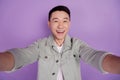 Photo of selfie blogger funny korean man take photo isolated violet color background
