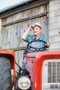 Senior farmer wearing hat diving tractor