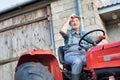 Low angle view of senior farmer wearing hat and driving tractor