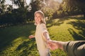 Photo of senior glad woman good mood hold hand husband follow me walk park sunny spring nature outdoors