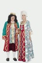 Portrait of senior king and queen standing over gray background Royalty Free Stock Photo