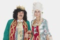 Portrait of senior king and queen standing over gray background Royalty Free Stock Photo