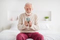 Photo of senior man pensioner happy positive smile sit bed indoors chat type browse internet cellphone Royalty Free Stock Photo