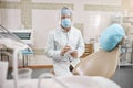 Elderly dentist wearing a visor and holding a tablet