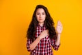 Photo of serious appreciative woman with wavy hairdo dressed checkered shirt hold arm on chest show respect isolated on