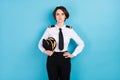 Photo of serious calm young woman wear pilot uniform professional hold hat isolated on blue color background