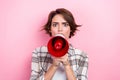 Photo of serious furious woman dressed plaid shirt creaming loud speaker isolated pink color background