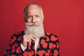 Photo of serious mature man touch elegant white beard wear heart print tuxedo isolated red background