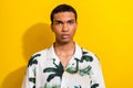 Photo of serious pleasant handsome man with nose piercing dressed palm print shirt look at camera isolated on yellow