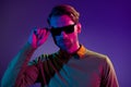 Photo of serious positive cool young man wear sunglass night club life isolated on gradient neon background Royalty Free Stock Photo