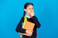 Photo of serious strict cool confident schoolgirl adjust spectacles hold books wear rucksack isolated on blue color