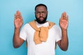 Photo of serious strict guy raise hands ban racism wear white t-shirt jumper front-tie isolated blue color background