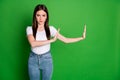 Photo of serious strict woman wear casual outfit showing stop gesture isolated green color background