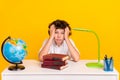 Photo of serious tired schoolboy dressed white shirt boring doing much homework isolated yellow color background