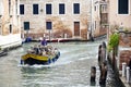 Photo of the service boat taken from a bridge near Grand canal in Venice, Italy.