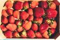 Several strawberries in a wooden box shot from above